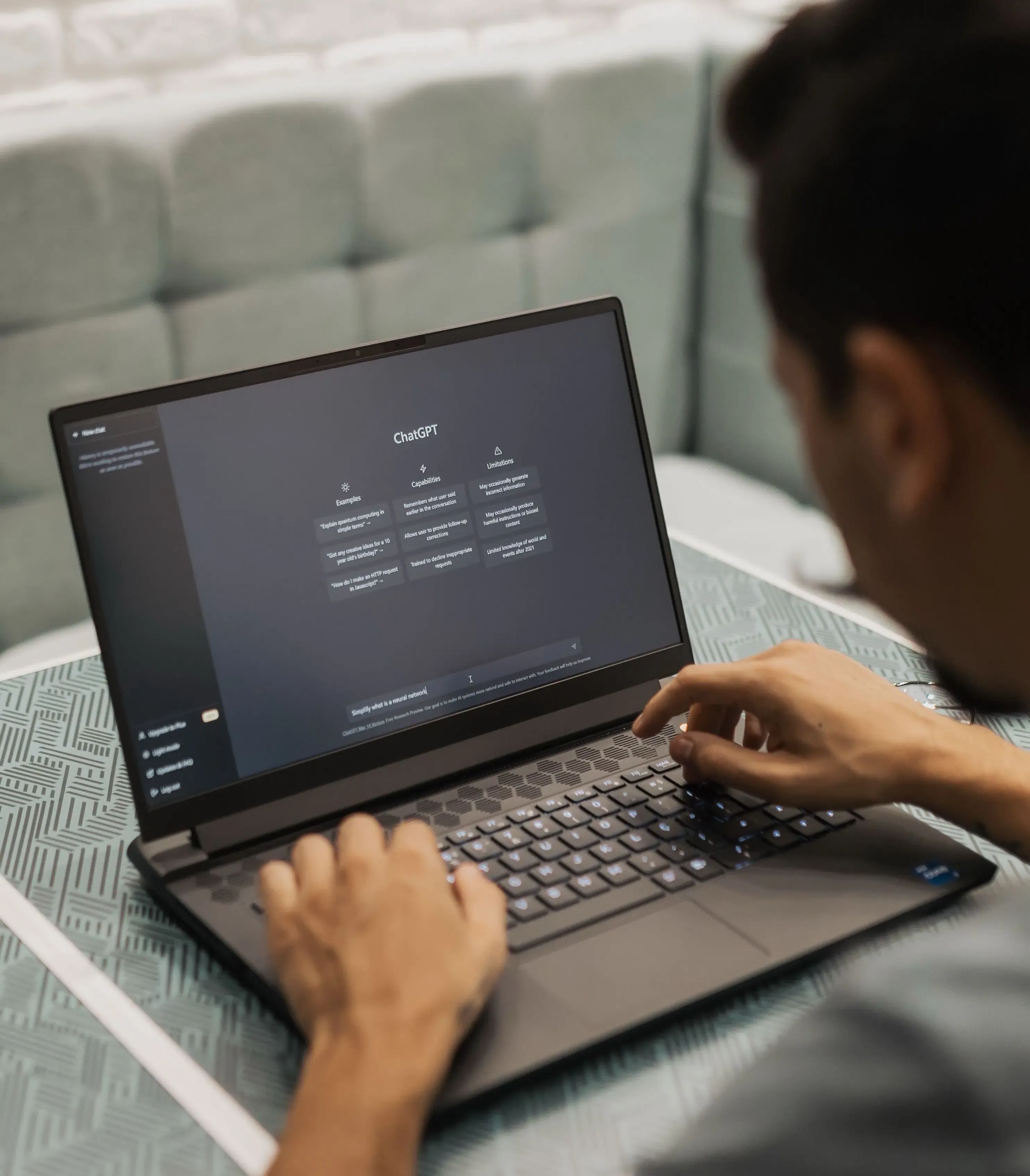 A person typing a prompt into ChatGPT on a laptop